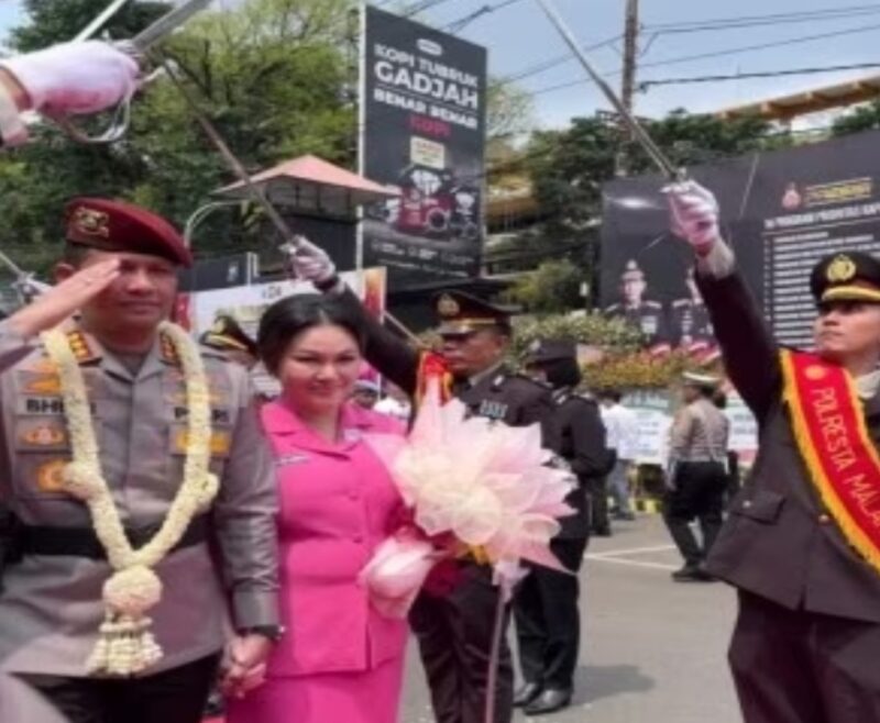 KOMBES Pol Budi Hermanto bersama istri Enic Budi Hermanto melewati barisan pedang pora di Mapolresta Malang Kota, Selasa (8/10/2024) (Foto Istimewa)