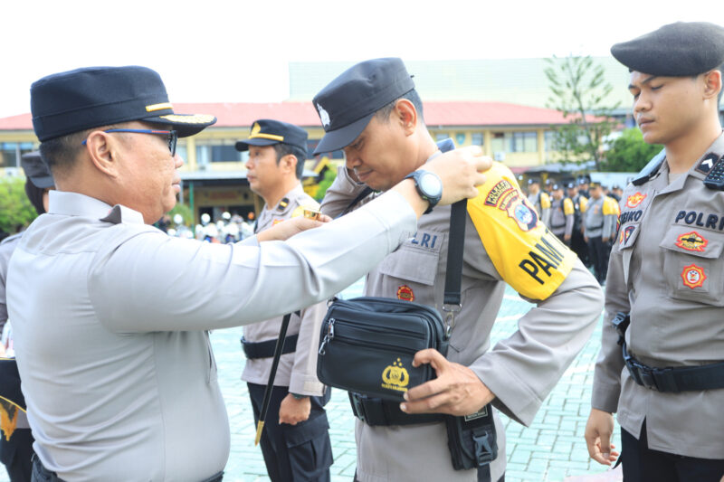 Kapolresta Banjarmasin Kombes Pol Cuncun Kurniadi saat memasang ban lengan tanda pengamanan petugas bergeser ke seluruh TPS dalam rangka Pencoblosan dan Perhitungan Pilkada Serentak 2024, Selasa 26/11/2024) pagi. (Foto Istimewa/Bomindonesia) 