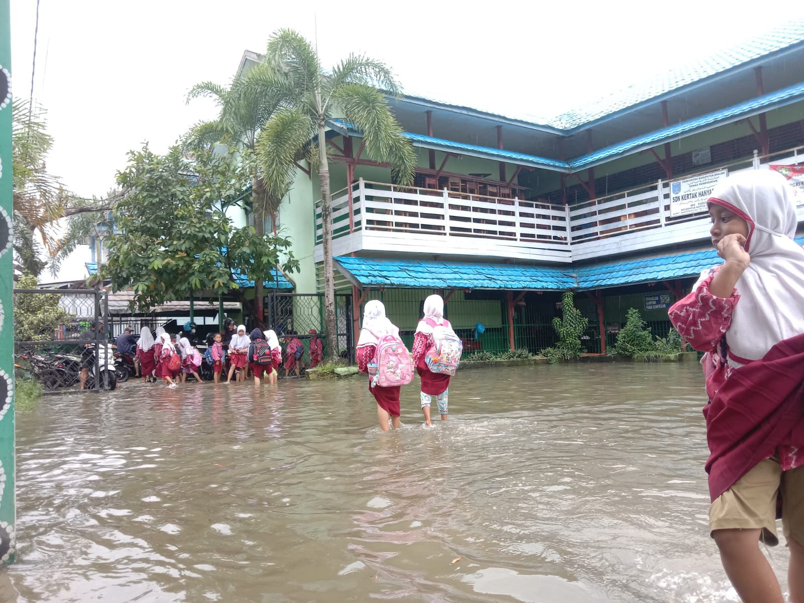 Halaman SDN Pemurus Dalam 5 Dilanda Meluapnya Air, hingga siswa harus menanggalkan sepatunya (tak beralas kaki) menuju sekolah