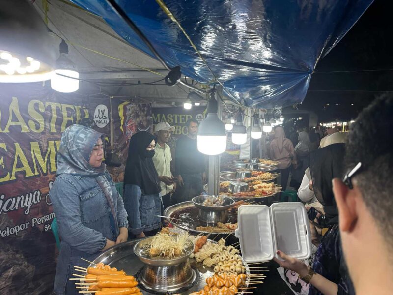Randy dan rekannya Adan yang kadang jadi Transformer (jual jasa foto kostum super hero) dan dua karyawati Master Steambot melayani pembeli di Pasar Wadai Ramadhan 1446 H di Jalan Jenderal Sudirman Banjarmasin (Foto Mercy)