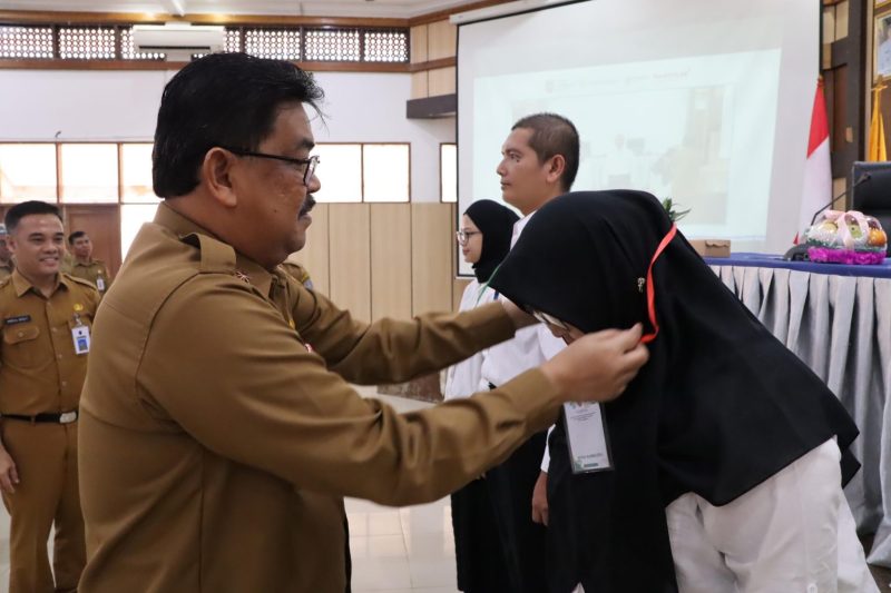 Plt Kepala Dinas Kesehatan Kalimantan Selatan Dr HM Muslim Mengalungkan Tanda Peserta pada Pembukaan Pelatihan Strategis (foto:mckalsel)