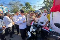 Kapolda Kalsel Irjen Pol Rosyanto Yudha Hermawan dan Gubernur Kalsel H. Muhidin saat membagikan bendera merah putih kepada pengendara motor di Jalan Lambung Mangkurat, Kamis (7/8/2025) (Foto Istimewa)