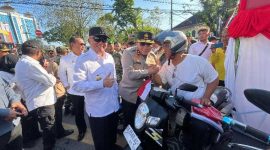 Kapolda Kalsel Irjen Pol Rosyanto Yudha Hermawan dan Gubernur Kalsel H. Muhidin saat membagikan bendera merah putih kepada pengendara motor di Jalan Lambung Mangkurat, Kamis (7/8/2025) (Foto Istimewa)