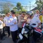 Kapolda Kalsel Irjen Pol Rosyanto Yudha Hermawan dan Gubernur Kalsel H. Muhidin saat membagikan bendera merah putih kepada pengendara motor di Jalan Lambung Mangkurat, Kamis (7/8/2025) (Foto Istimewa)
