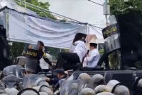 Ajudan dan aparat tampak sigap melindungi bupati dari serangan lemparan botol dan sendal (Foto Istimewa)