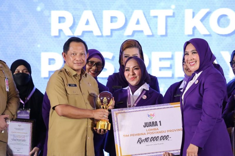 Menteri Dalam Negeri, Muhammad Tito Karnavian bersama Ketua Umum Tim Pembina Posyandu Pusat, Tri Tito Karnavian Menyerahkan Penghargaan kepada Hj Fathul Jannah Muhidin