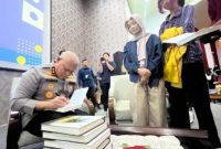 Kapolda Kalsel Irjen Pol Rosyanto Yudha Hermawan menandatangani buku “Arkeologi Kepemimpinan” seusai kegiatan bedah buku di Auditorium Prof Idham Zarkasi Fakultas Hukum ULM Banjarmasin, Selasa (21/10/2025) (Foto kolase /Istimewa)