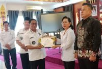 Bupati Heriyus saat memberikan cendramata kenang-kenangan kepada Kadisdukcapil Regita (foto: Maya)