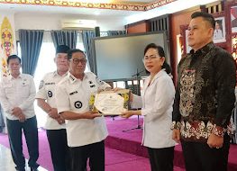 Bupati Heriyus saat memberikan cendramata kenang-kenangan kepada Kadisdukcapil Regita (foto: Maya)