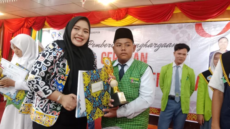 Wakil Ketua I DPRD Murung Raya, Dina Maulidah, saat memberikan piagam penghargaan kepada salah satu peserta pemenang Lomba Bertutur (foto: Maya)