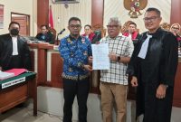 Terdakwa Habib Muchdar (kedua dari kanan) berjabat tangan dengan korban Abrar Ibrahim (kedua dari kiri) sambil menunjukkan surat perdamaian di hadapan majelis hakim PN Banjarmasin, didampingi kuasa hukum Ar Rafi, SH (kanan), dan Jaksa Penuntut Umum
Adhyaksa Putera, SH (paling kiri bermasker) (Foto Mercy)