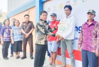 Ketua DPRD Rumiadi saat menyerahkan bantuan pangan beras dan minyak goreng kepada keluarga penerima manfaat (foto: Maya)