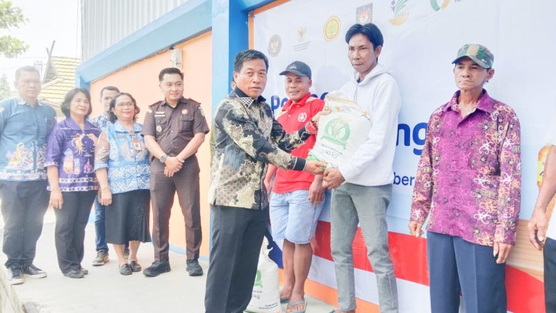 Ketua DPRD Rumiadi saat menyerahkan bantuan pangan beras dan minyak goreng kepada keluarga penerima manfaat (foto: Maya)