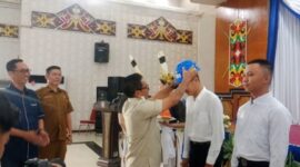 Bupati Heriyus saat memasangkan helm kepada peserta magang (foto: Maya)