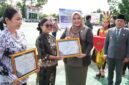 Wakil Ketua I DPRD Murung Raya Dina Maulidah, S.HI saat menyerahkan piagam penghargaan pada upacara peringatan Hari Otda ke-XXX dan Hardiknas (foto: Maya)