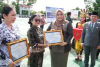 Wakil Ketua I DPRD Murung Raya Dina Maulidah, S.HI saat menyerahkan piagam penghargaan pada upacara peringatan Hari Otda ke-XXX dan Hardiknas (foto: Maya)