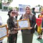 Wakil Ketua I DPRD Murung Raya Dina Maulidah, S.HI saat menyerahkan piagam penghargaan pada upacara peringatan Hari Otda ke-XXX dan Hardiknas (foto: Maya)