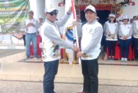 Bupati Murung Raya Heriyus saat menyerahkan bendera kontingen FBIM sebagai simbol dukungan dan kepercayaan kepada peserta (foto: Maya)