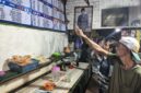 ANTUSIAS PIALA DUNIA – Sejumlah pelanggan Warung Kai Adi di Jalan Kolonel Sugiono/Pekapuran B, Banjarmasin Tengah, antusias mengamati jadwal pertandingan Piala Dunia yang terpampang di warung tersebut. Suasana diskusi dan prediksi antarpendukung tim favorit mulai ramai mewarnai warung-warung kopi menjelang bergulirnya turnamen sepak bola terbesar di dunia. (foto:Mercy )
