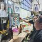 PANTAUJADWAL PIALA DUNIA – Arief dan Memet memperhatikan jadwal pertandingan Piala Dunia 2026 pada poster kecil sambil menikmati mi di Warung Kai Adi, Banjarmasin. Demam Piala Dunia mulai terasa di kalangan pencinta sepak bola yang bersiap begadang mendukung tim favorit mereka. (foto: Mercy )