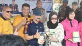 PASAR MURAH DISERBU – Kapolda Kalimantan Selatan Irjen Pol Dr Rosyanto Yudha Hermawan didampingi 
Ketua Bhayangkari Daerah Kalimantan Selatan Ny. Yennie Rosyanto Yudha bersama Kepala Dinas Pertanian dan Ketahanan Pangan Kalsel Syamsir Rahman ikut  melayani pembeli di stan pasar murah yang diserbu warga pada kegiatan Car Free Day Hari Bhayangkara ke-80 di Banjarmasin, Minggu (28/6/2026). (Foto: Mercy)
