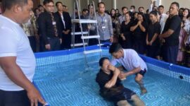 PROSESI BAPTISAN – Salah seorang peserta menjalani prosesi baptisan pada hari kedua Pertemuan Regional Saksi-Saksi Yehuwa 2026 bertema 